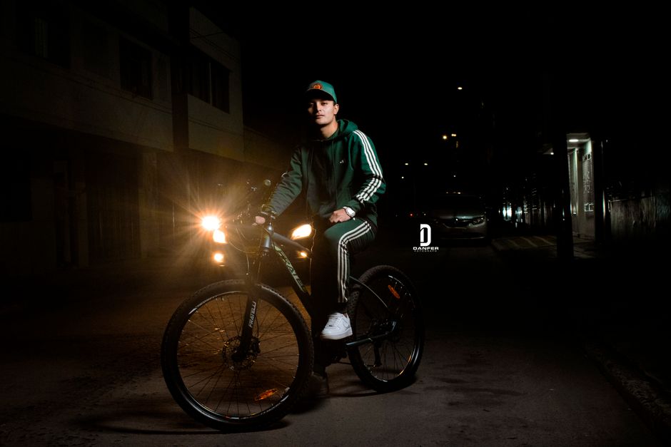 A man riding a bicycle at night on a street in Bogotá, Colombia.