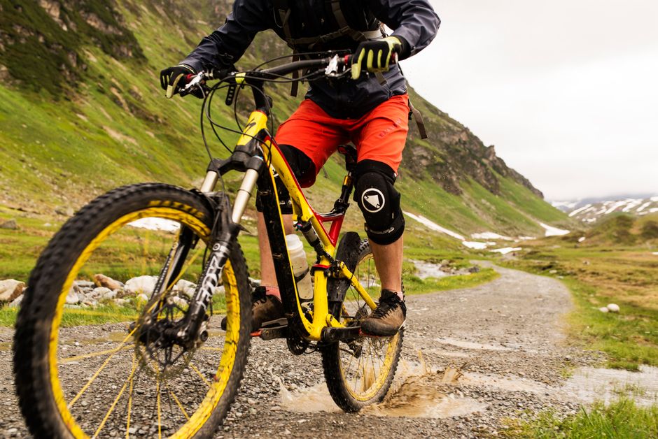 Mountain biker on a muddy trail suited to wet-season gravel tires