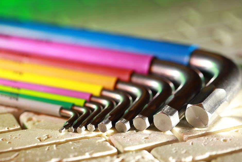 Vibrant set of Allen wrenches on a beige textured surface, showcasing creativity in tools.